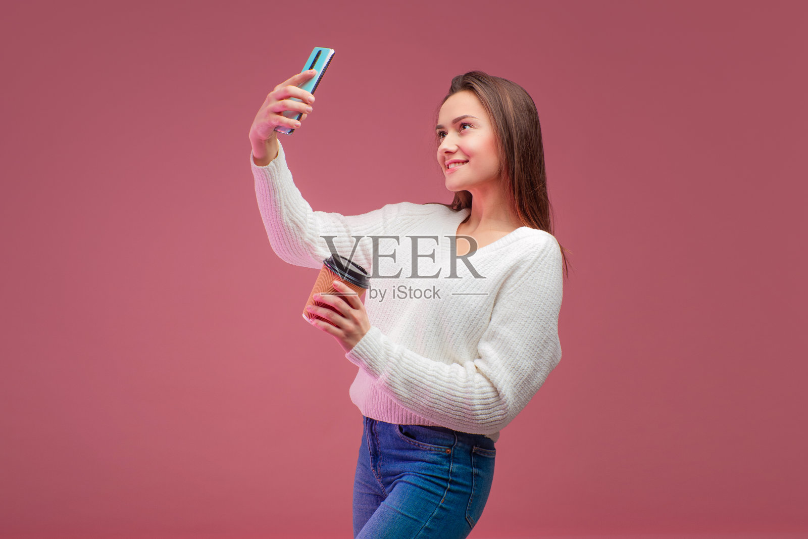 毛衣牛仔裤的迷人年轻黑发女郎照片摄影图片