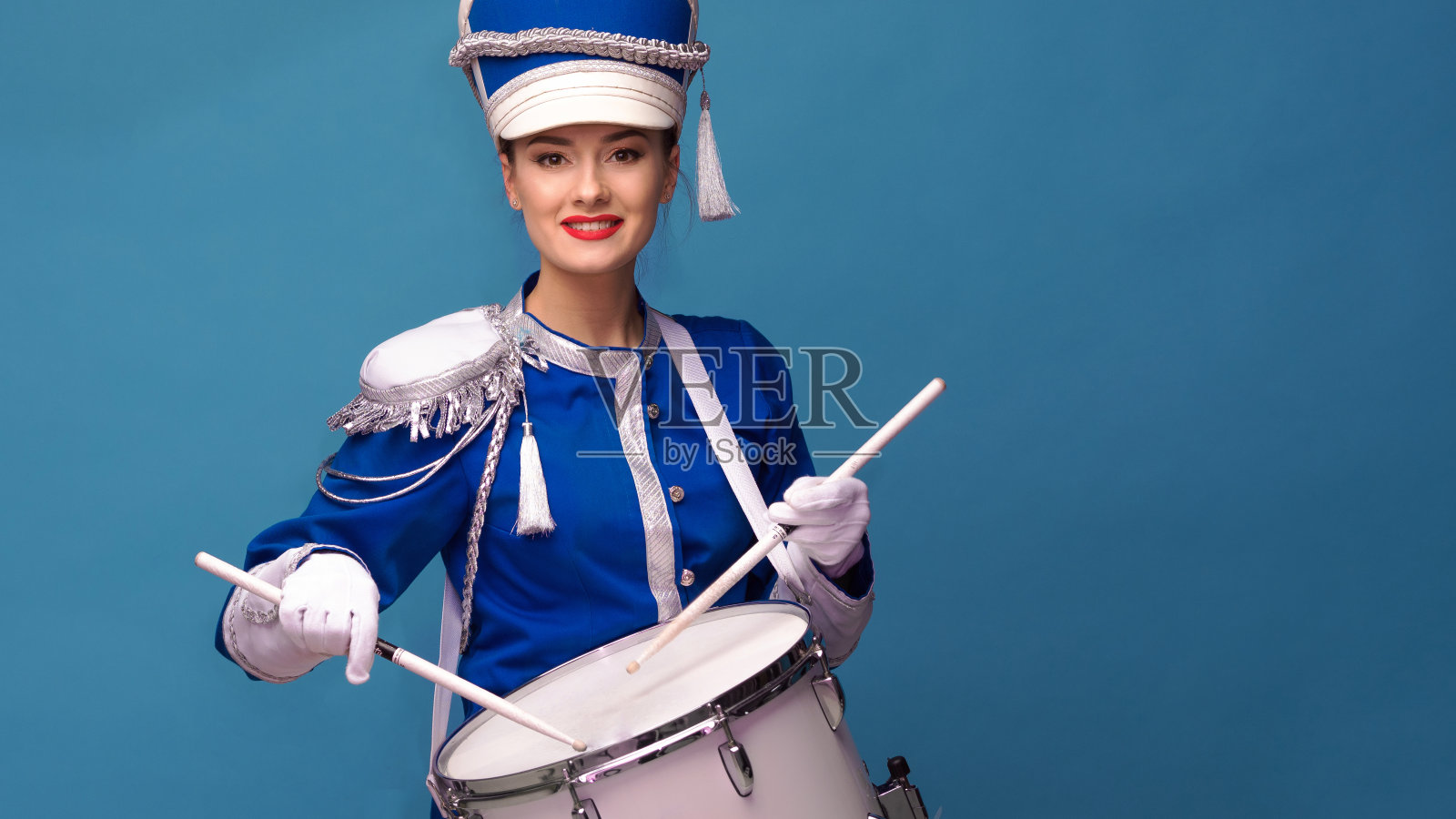 鼓手身着蓝色制服敲着鼓,表演节目和庆祝活动。照片摄影图片