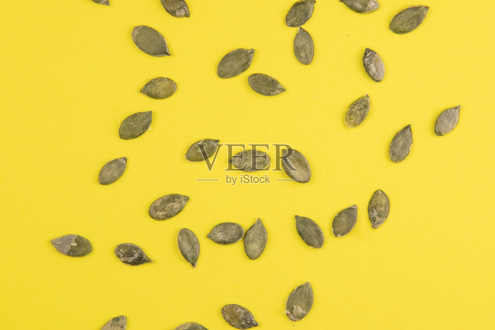 黄色背景上的南瓜子照片摄影图片