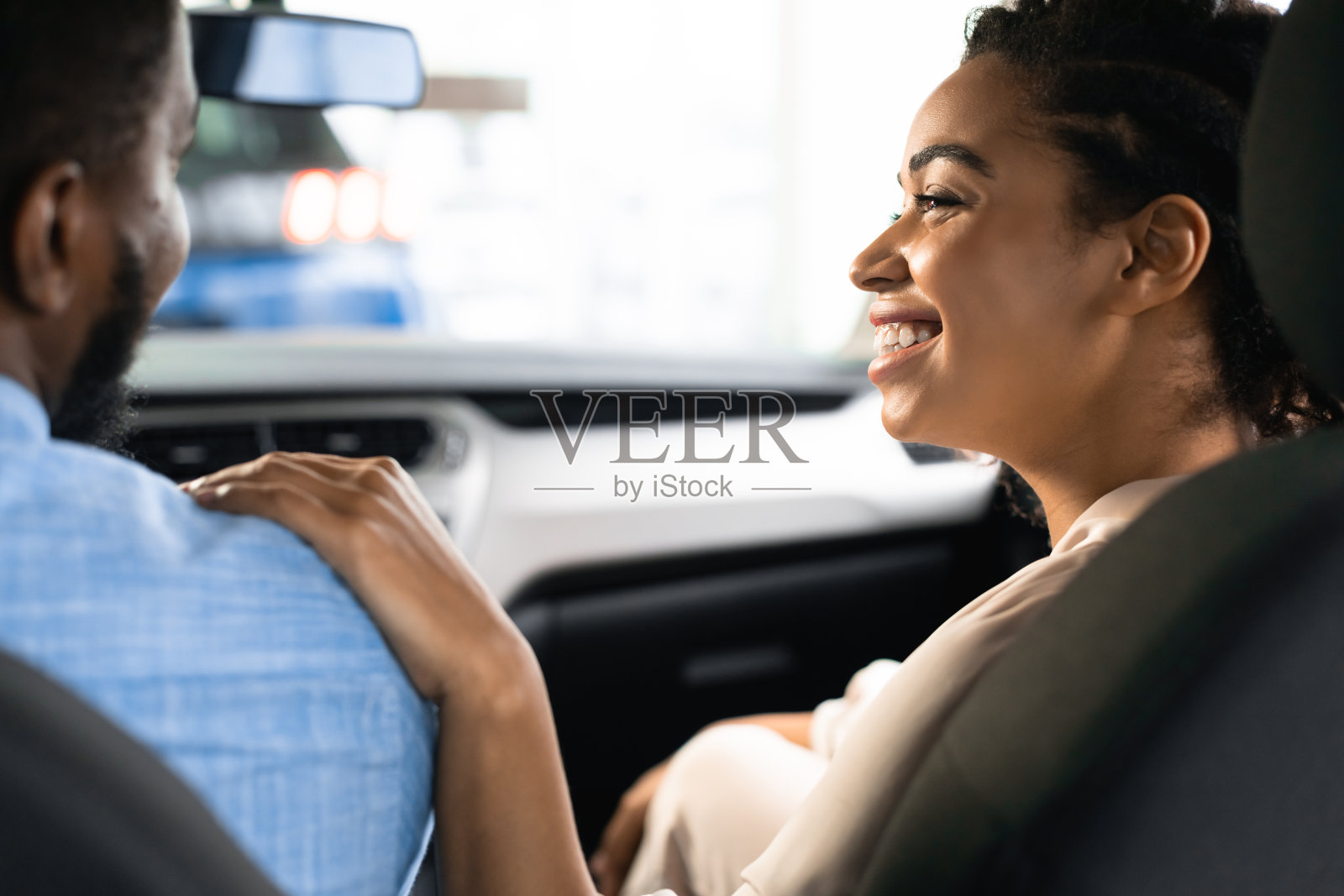 妻子摸着丈夫的肩膀在经销中心买新车照片摄影图片