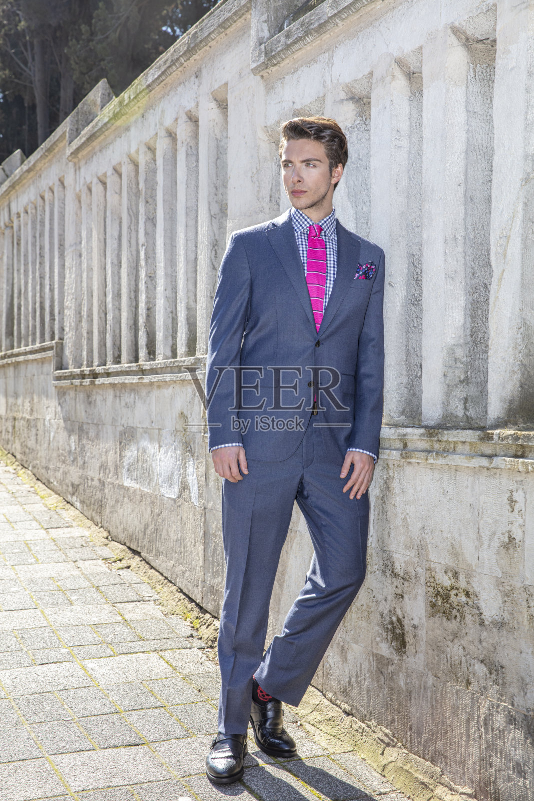 身穿海军蓝西装的年轻英俊男模特,在城市户外照片摄影图片