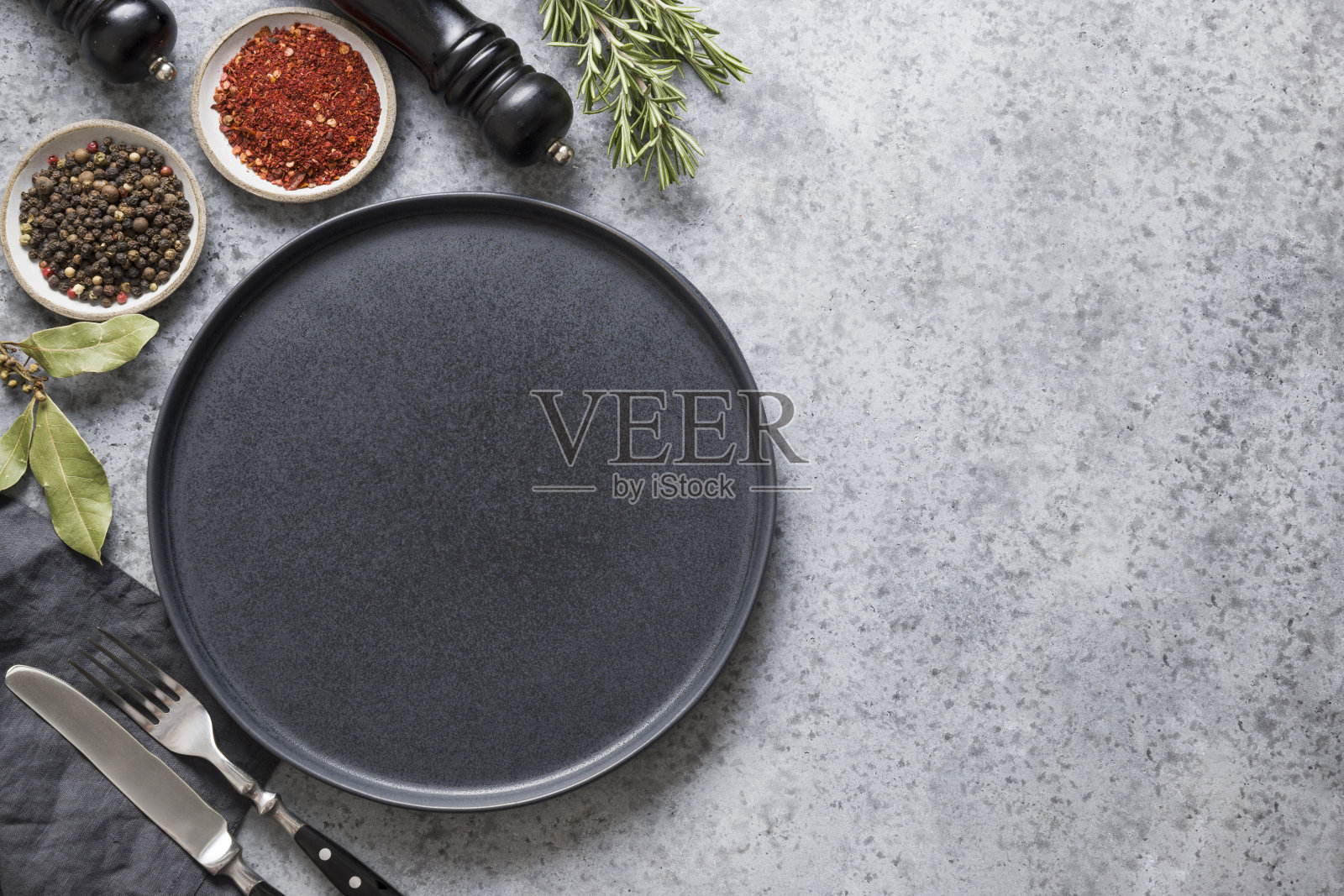 厨房里空着黑色的浅盘,灰色的浅盘上放着香料和配料。空间的文本。从以上观点。照片摄影图片