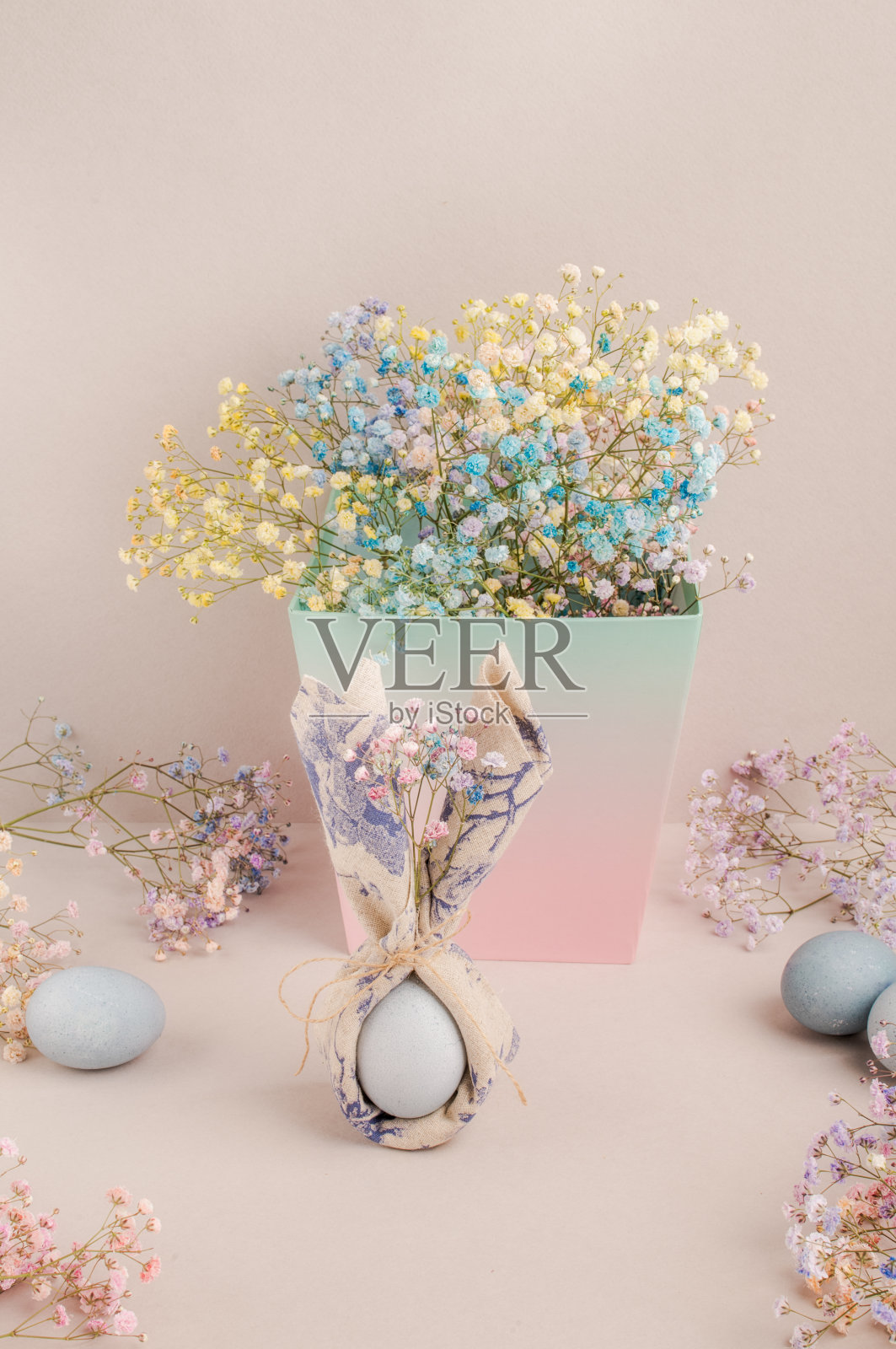 餐巾里的复活节彩蛋。兔耳朵下面盖着餐巾。照片摄影图片