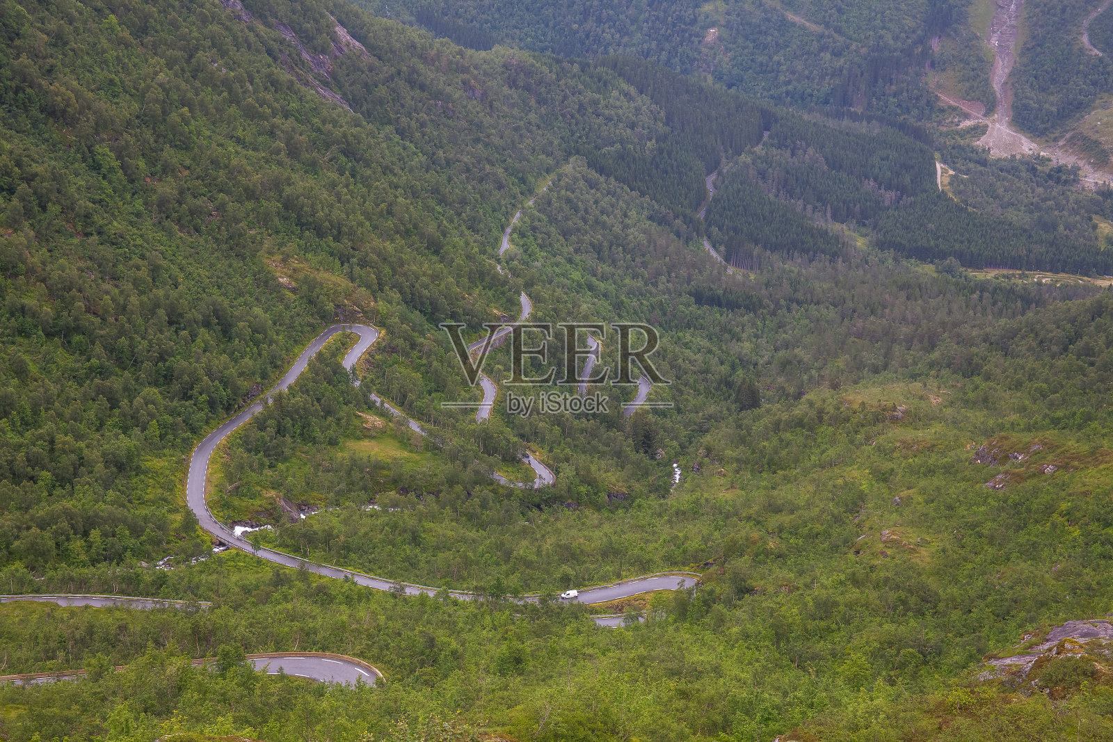 在挪威,一条土路穿过山谷之间的山脉,选择性的焦点照片摄影图片