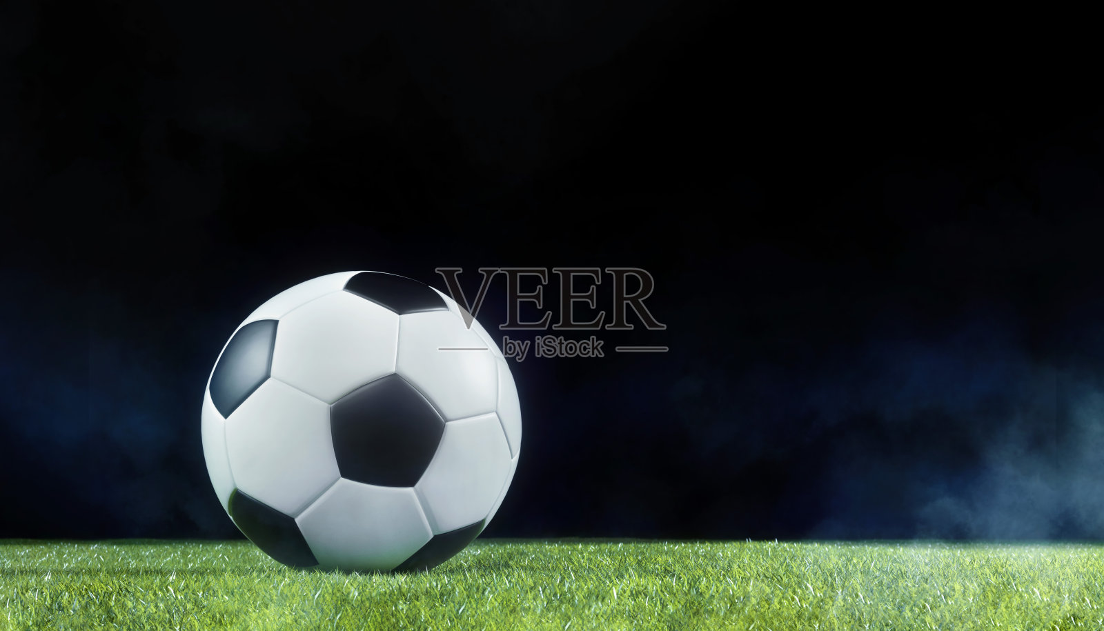 传统的足球是在夜晚灯光照亮的运动场上进行的照片摄影图片