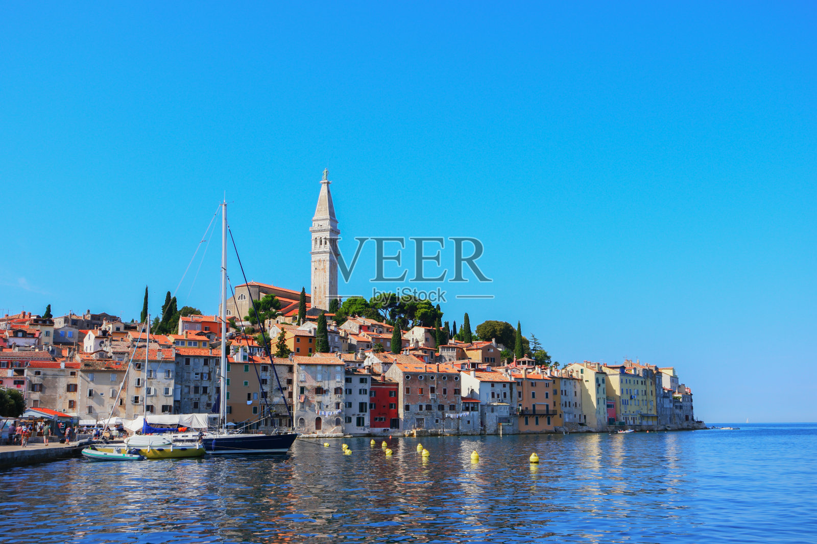 克罗地亚罗维尼城市风光,港口旁的教堂和古老房屋照片摄影图片