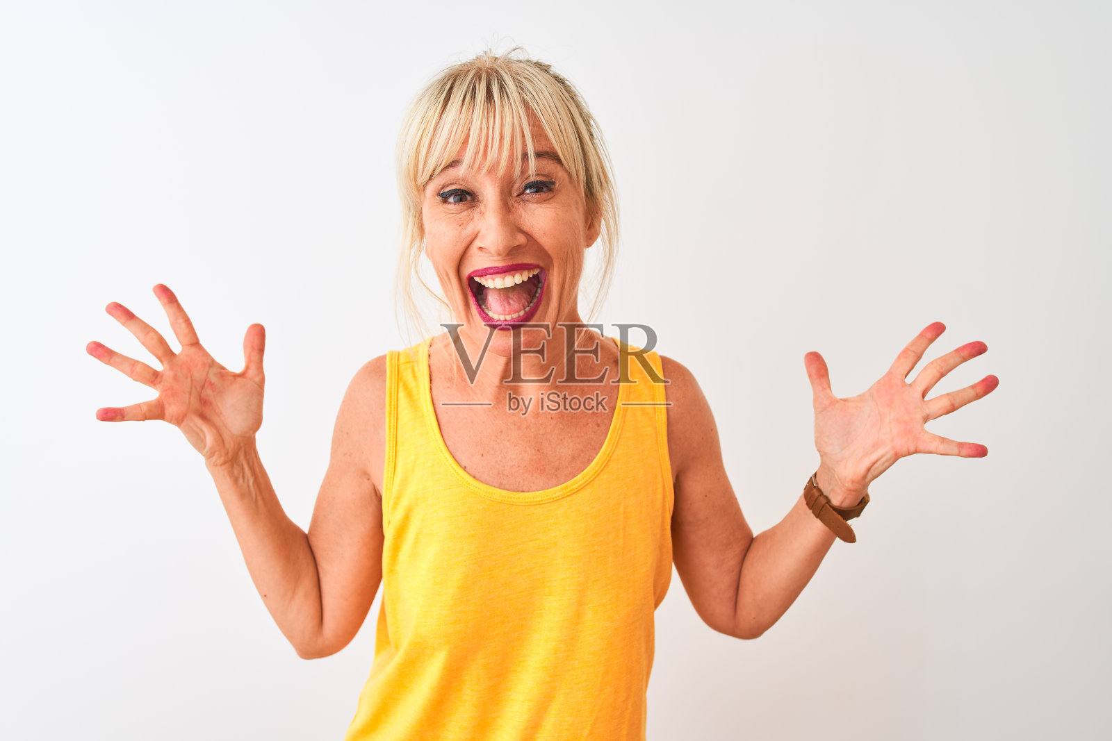 身穿黄色休闲T恤的中年妇女,张开双臂,为成功欢呼雀跃照片摄影图片