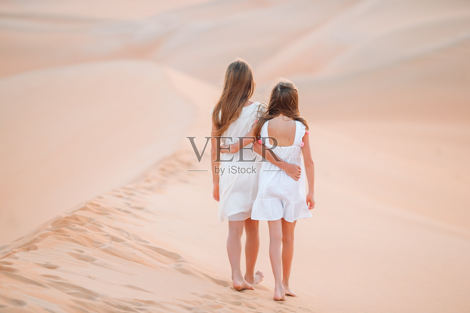 在阿拉伯联合酋长国鲁卜哈利沙漠沙丘中的女孩们照片摄影图片