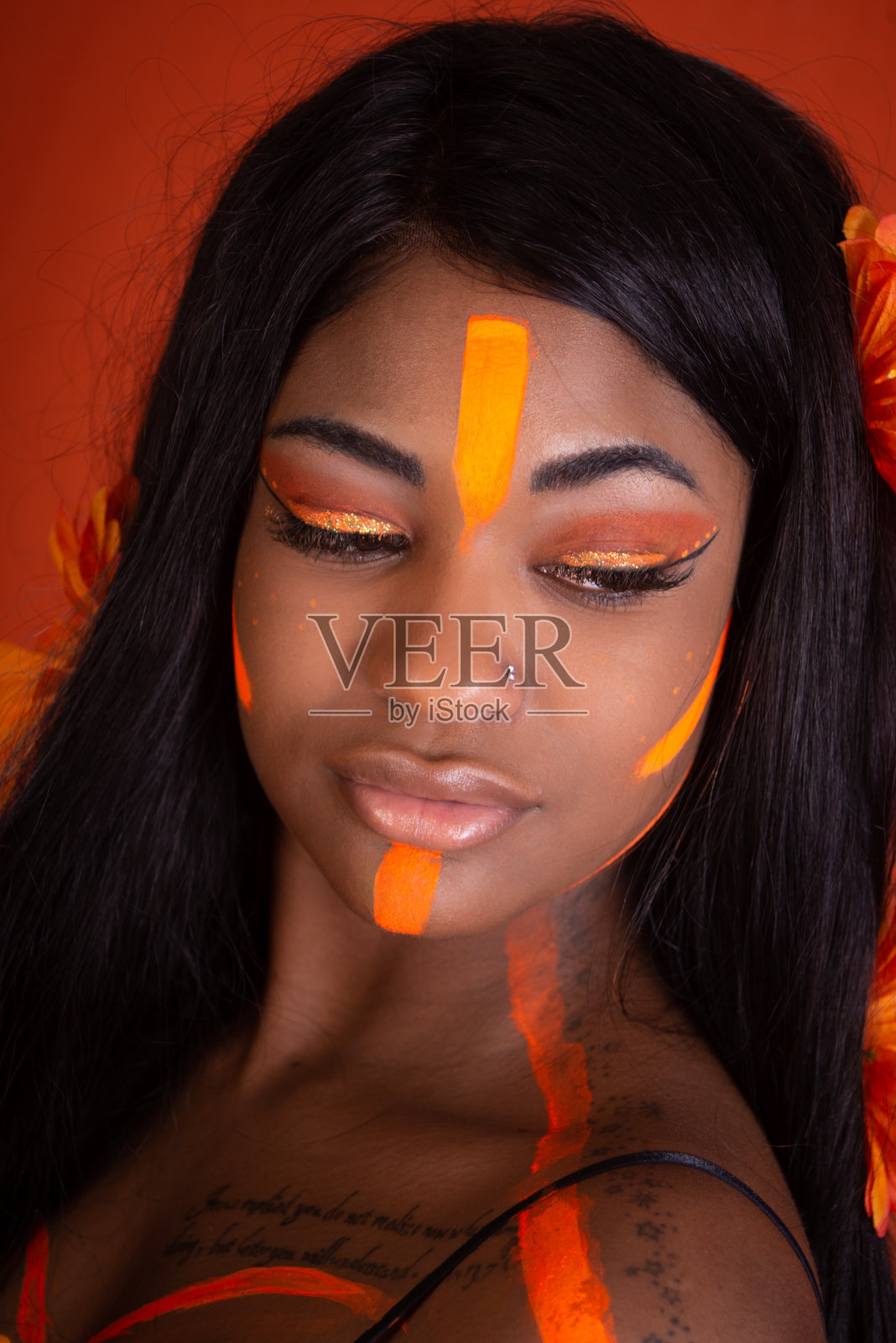 穿着橙色霓虹妆的年轻黑人女性。照片摄影图片