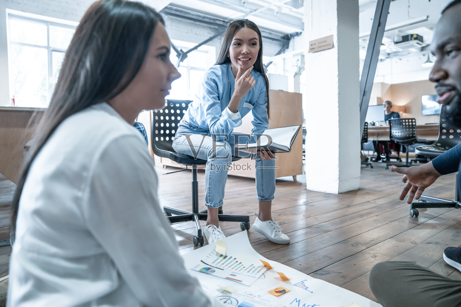 分享观点:一群自信的商务人士看着地板上的蓝图讨论事情照片摄影图片