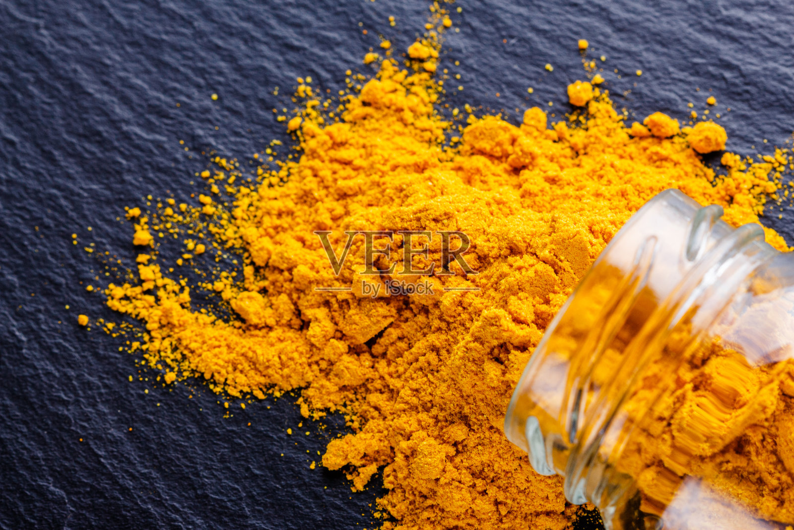 天然姜黄粉在黑色的石头背景照片摄影图片