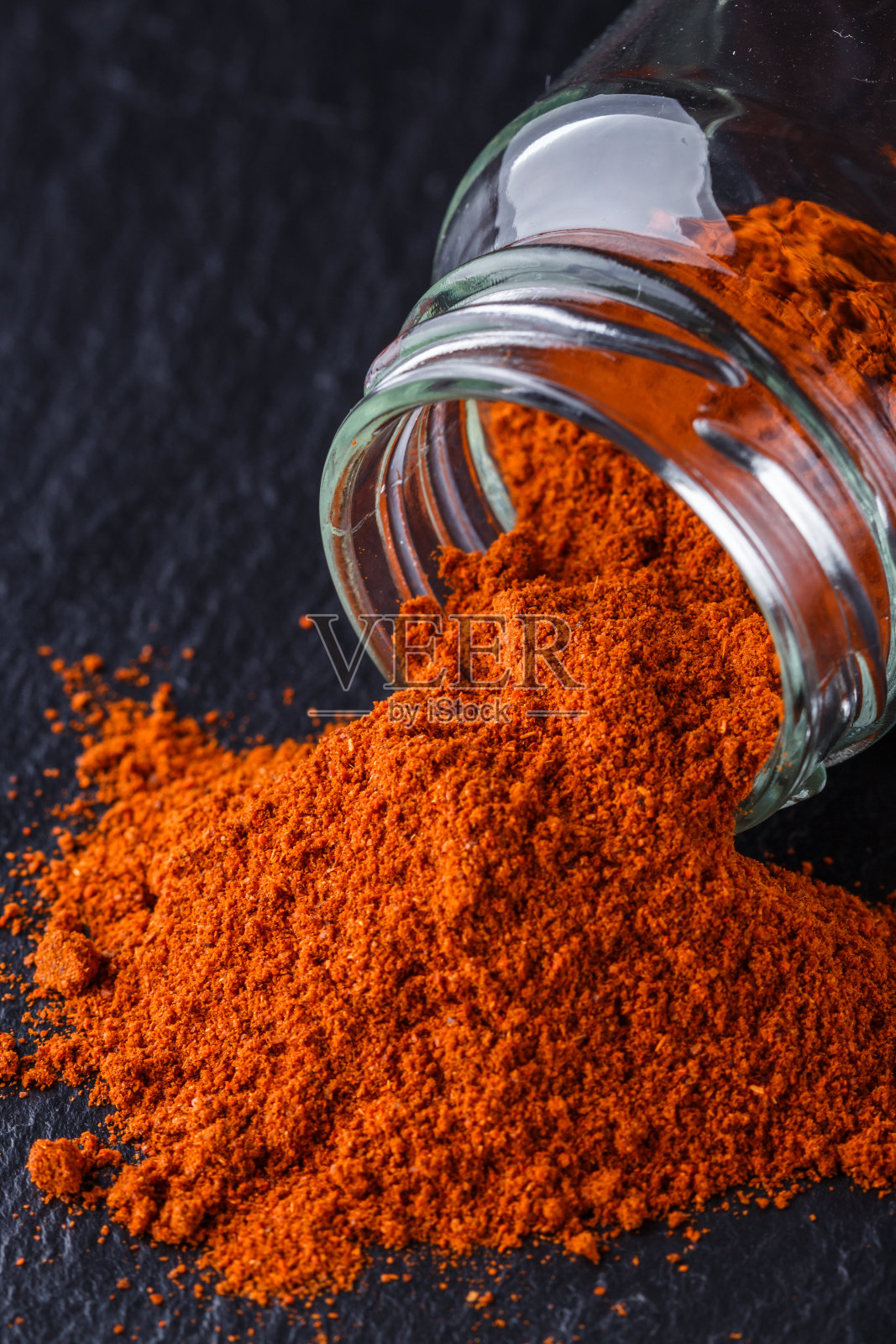 香辣的辣椒粉在黑色的石头背景上照片摄影图片