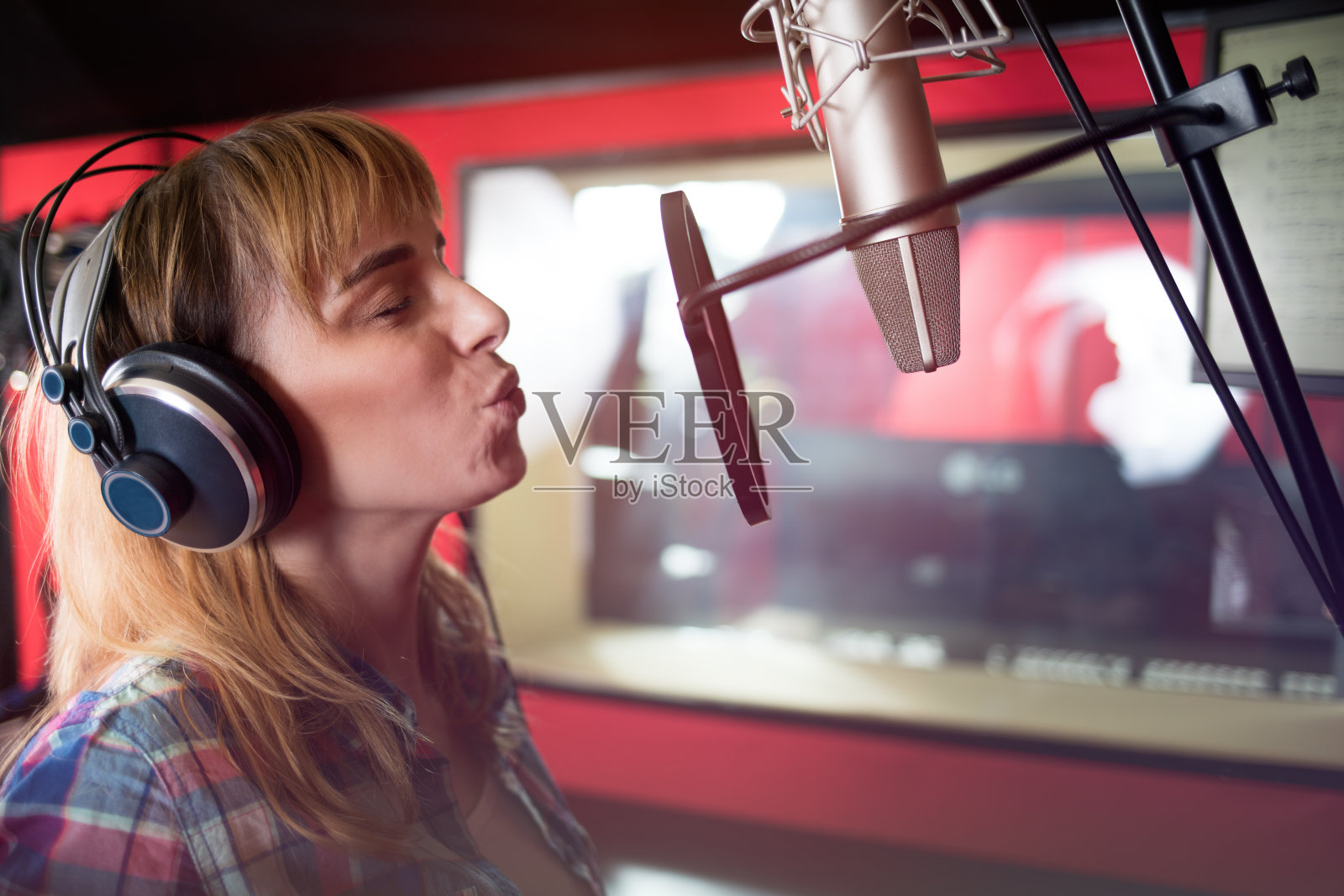 在录音棚录音的年轻女歌手照片摄影图片