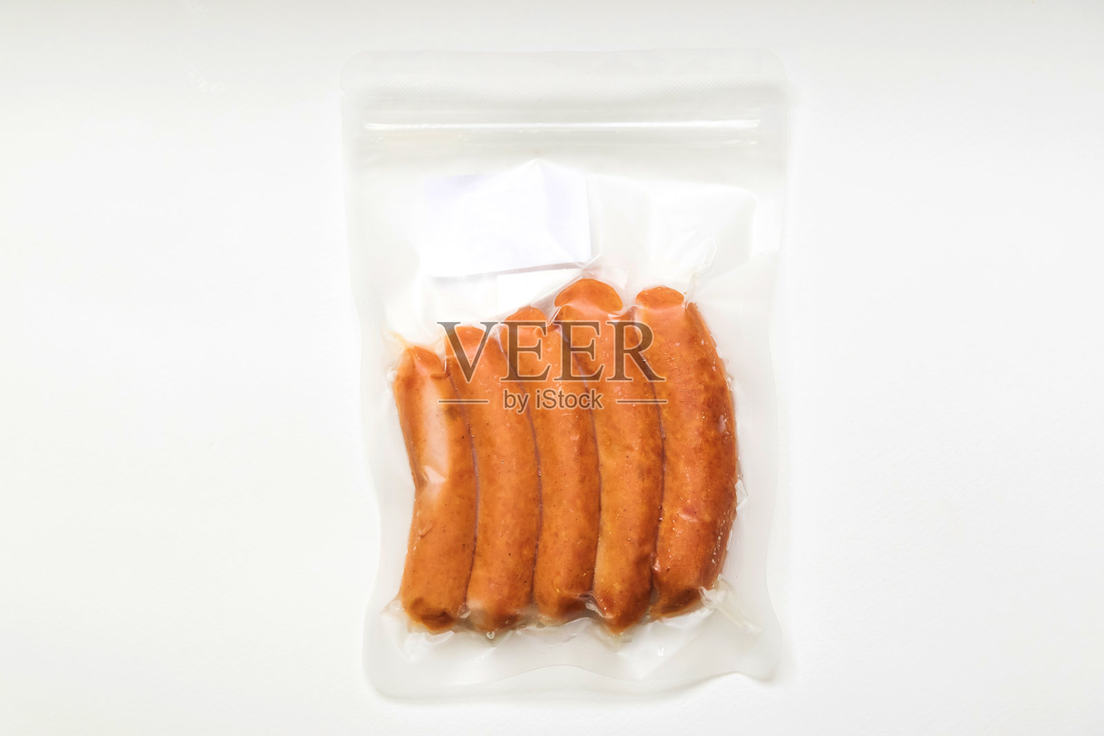 真空包装的鸡肉香肠在白色背景上隔离。照片摄影图片