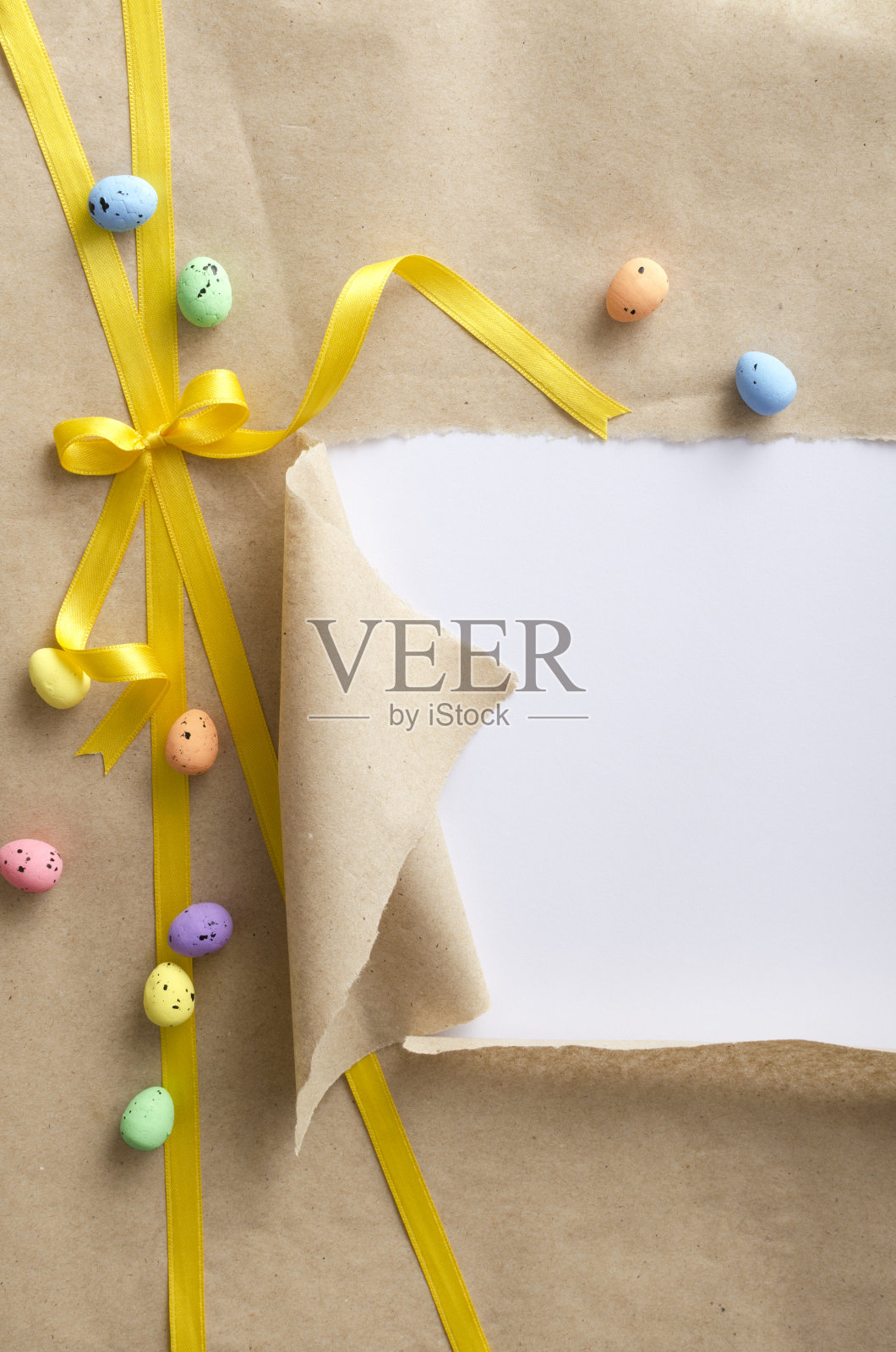 垂直的图像。亮黄色的丝带和蝴蝶结,装饰复活节鹌鹑蛋的撕纸工艺品。简易礼物和礼物的概念。设计空间照片摄影图片
