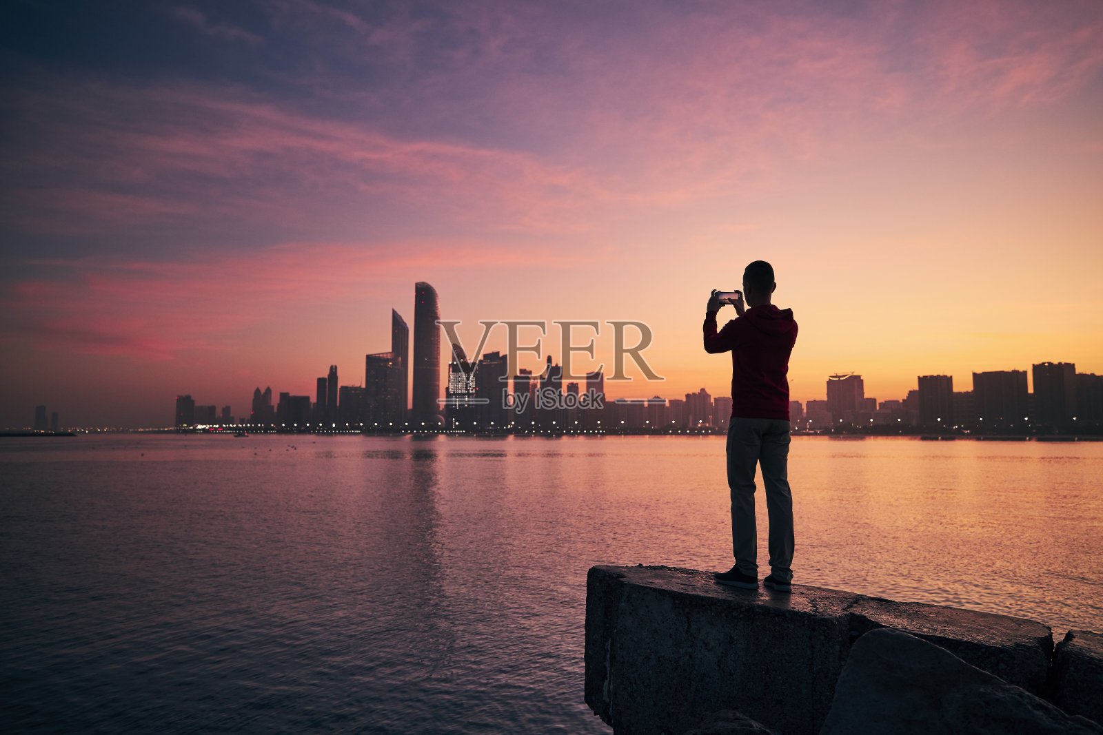 日出时使用手机的男人照片摄影图片
