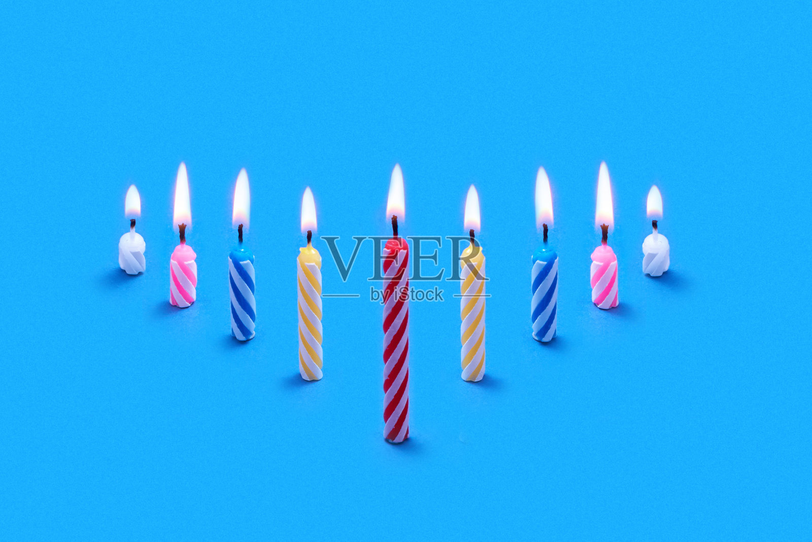 从燃烧的节日蜡烛蛋糕的透视构图。照片摄影图片