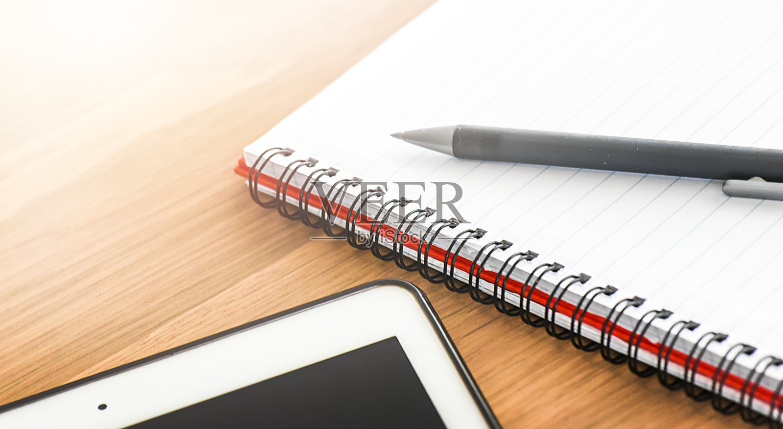 桌面笔记本电脑或带空白屏幕的现代电脑,置于乡村风格桌面上。螺旋笔记本放置在带笔和背光的木制桌面上。商务笔记本细节概念照片摄影图片