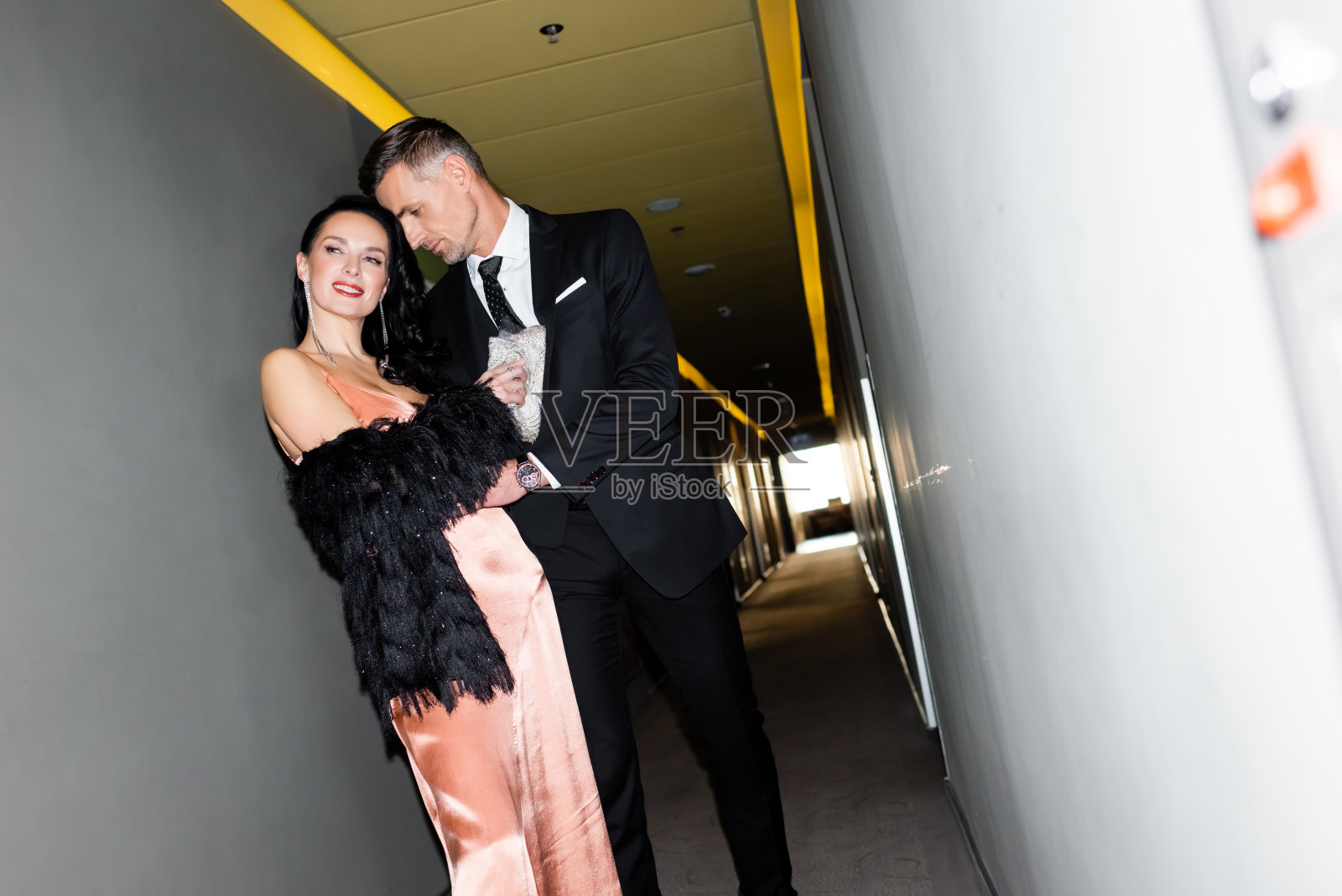 在酒店里拥抱微笑女友的英俊男友照片摄影图片