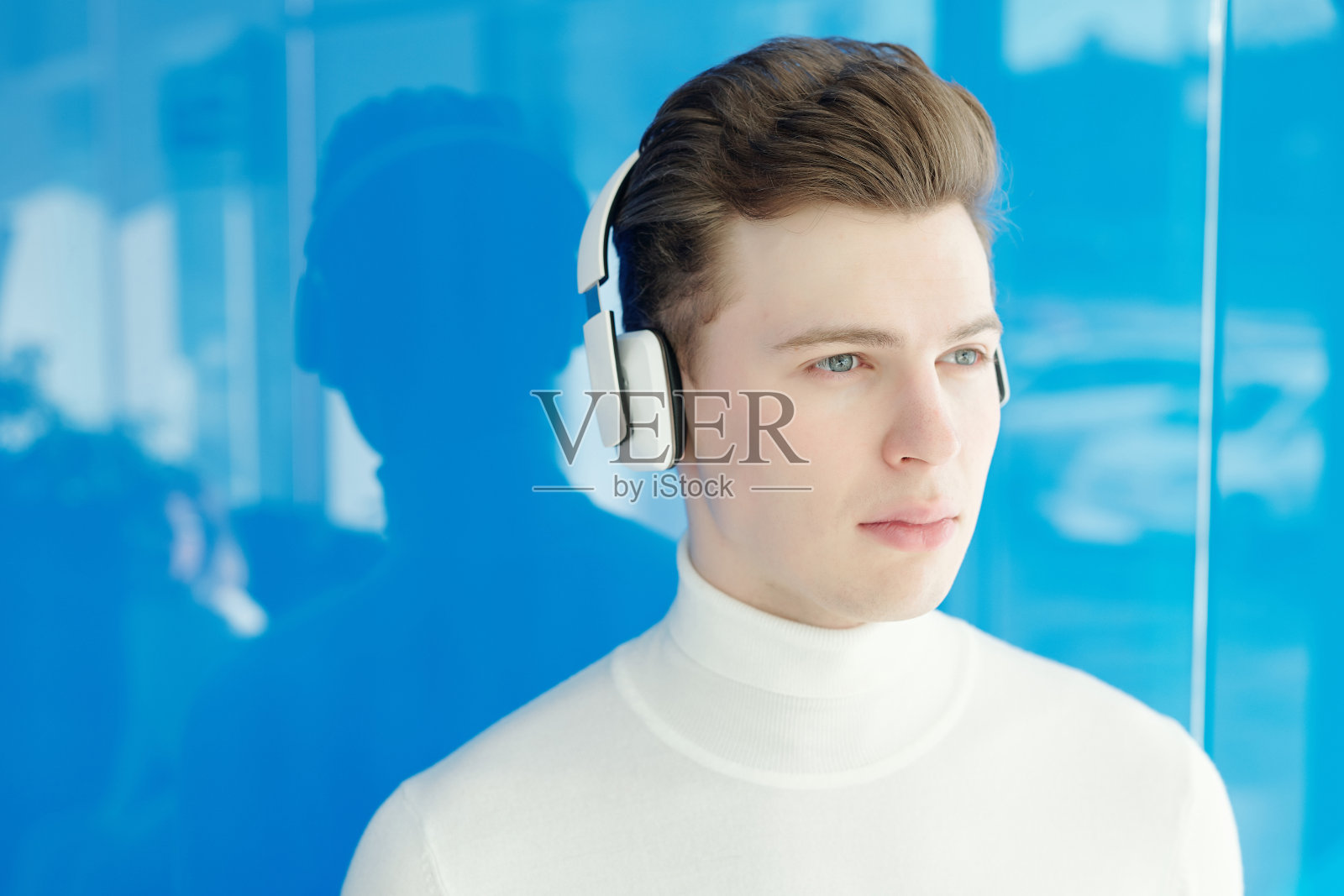 戴着现代耳机的严肃男人照片摄影图片