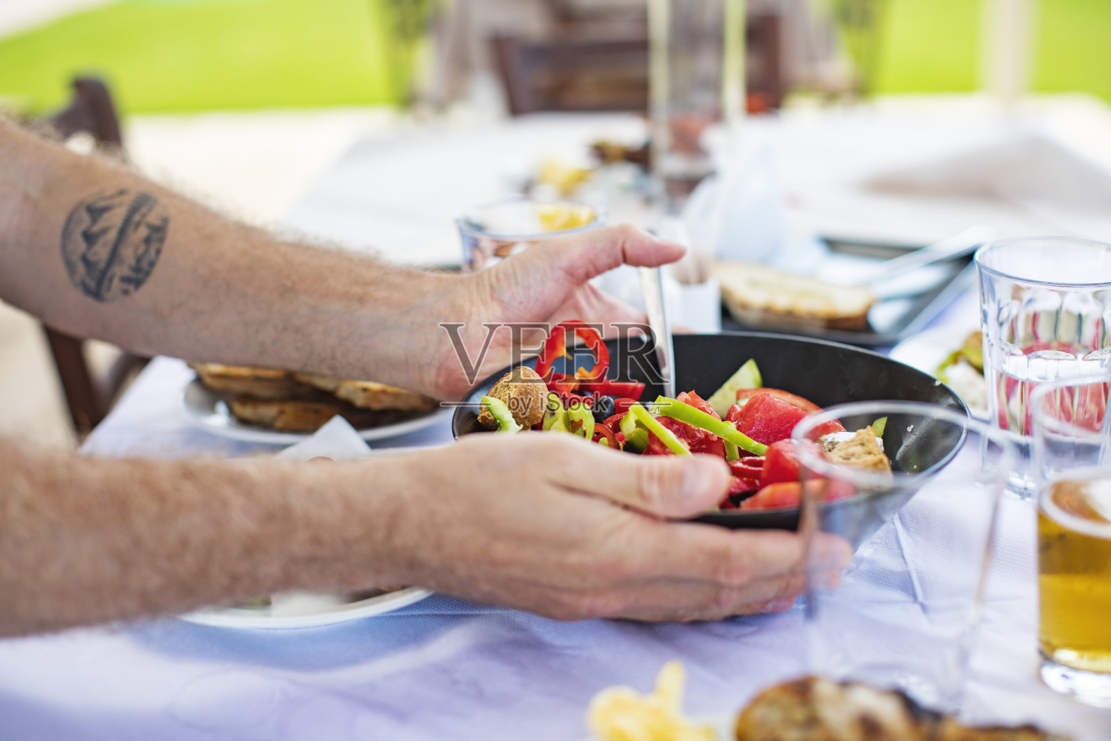 男人们在吃希腊沙拉照片摄影图片