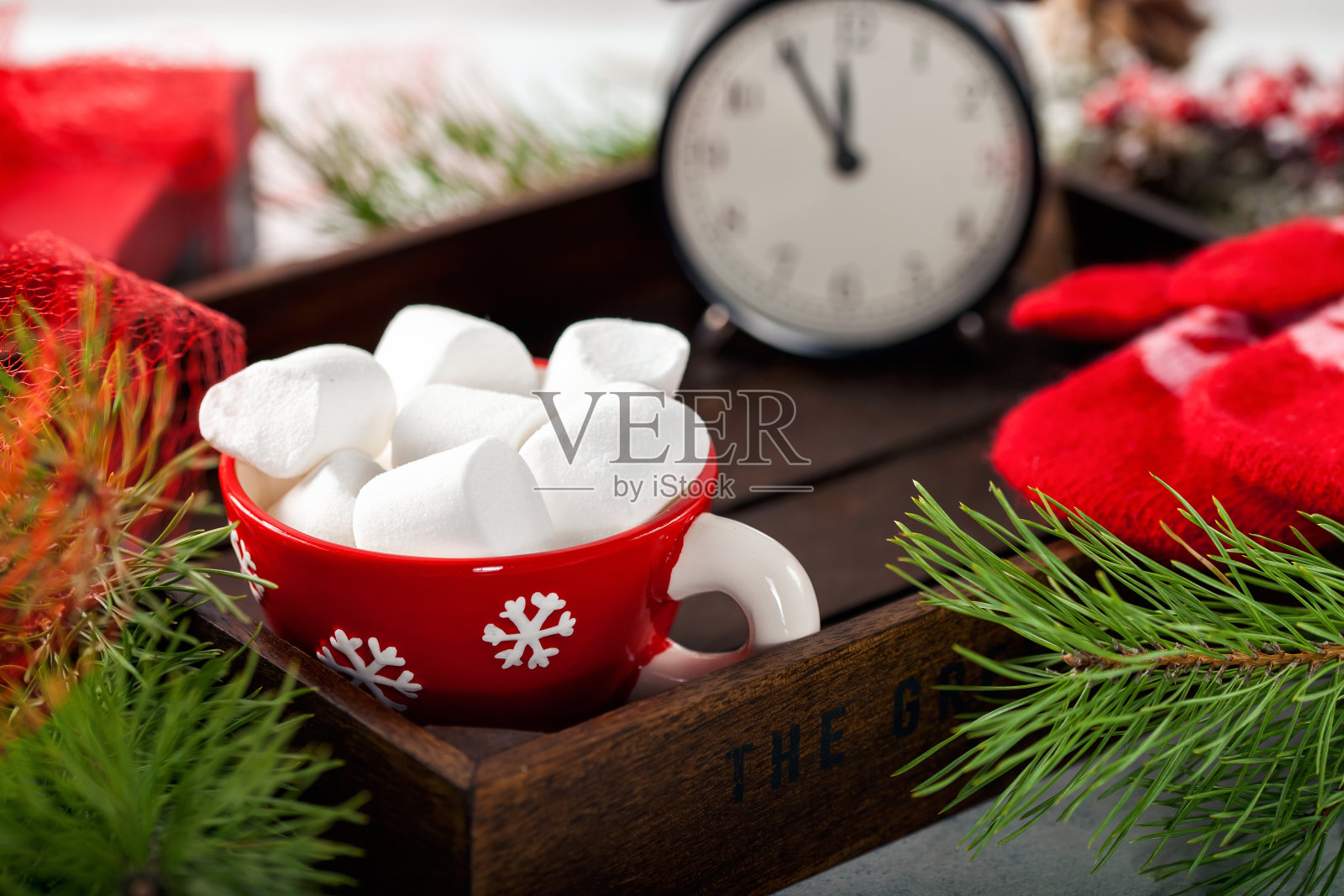 圣诞贺卡。杉树,手套,盒子,闹钟和棉花糖放在木桌上。有选择性的重点照片摄影图片