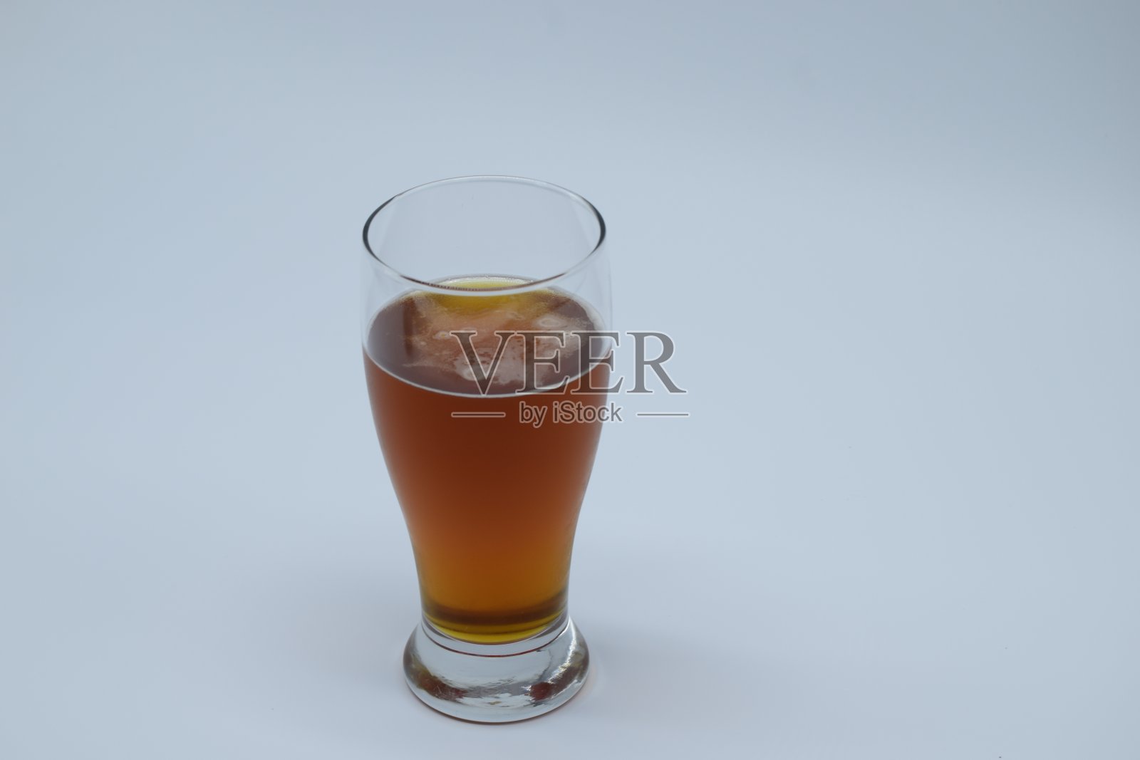 特写冷金黄色的啤酒与凝结在玻璃上的白色背景照片摄影图片