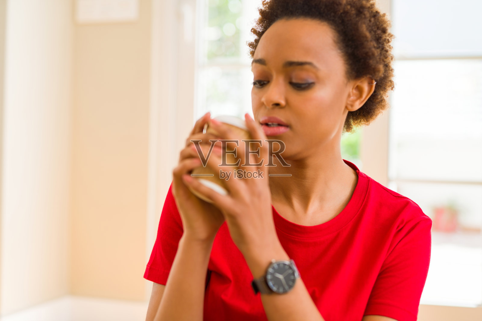 手持外卖纸杯喝咖啡的年轻非裔美国女子照片摄影图片