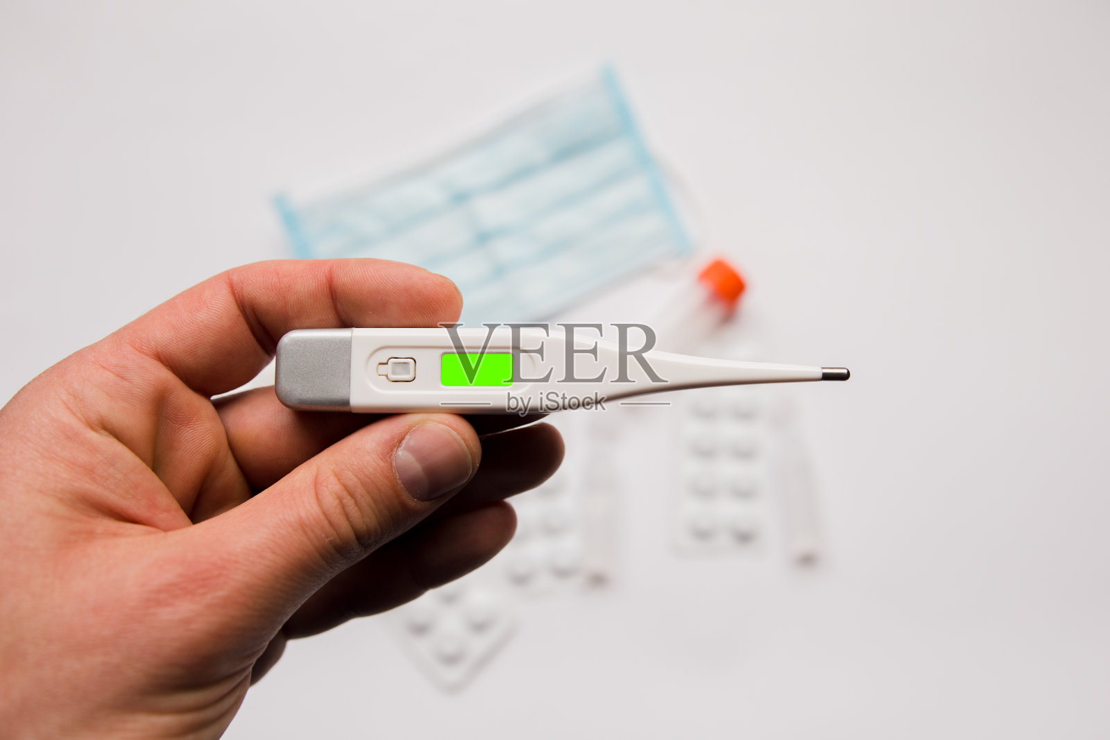 白色背景上带药物的电子温度计照片摄影图片