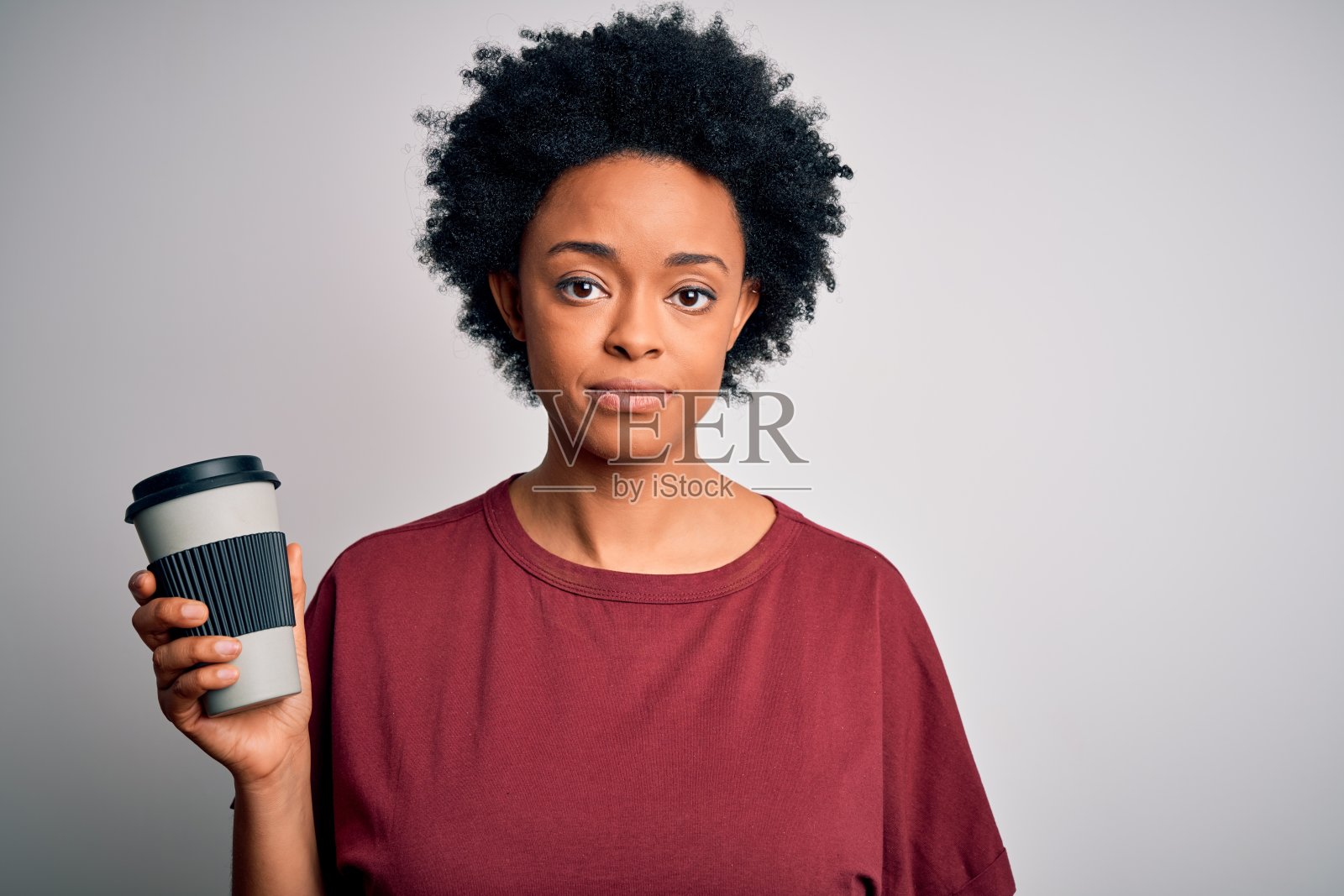 喝着咖啡,面露自信表情的年轻非裔美国女性照片摄影图片