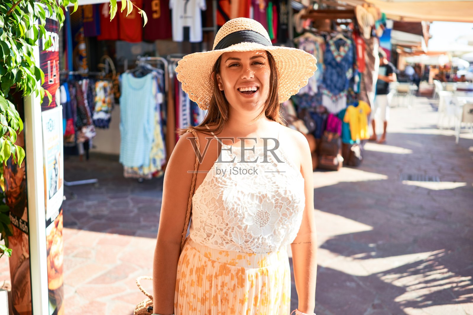 在一个阳光明媚的日子里,年轻美丽的女人走在浪漫的村庄的街道上照片摄影图片