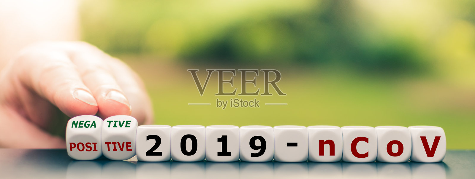 电晕测试结果。手转动骰子,将表达“阳性2019-nCoV”变为“阴性2019-nCoV”。照片摄影图片