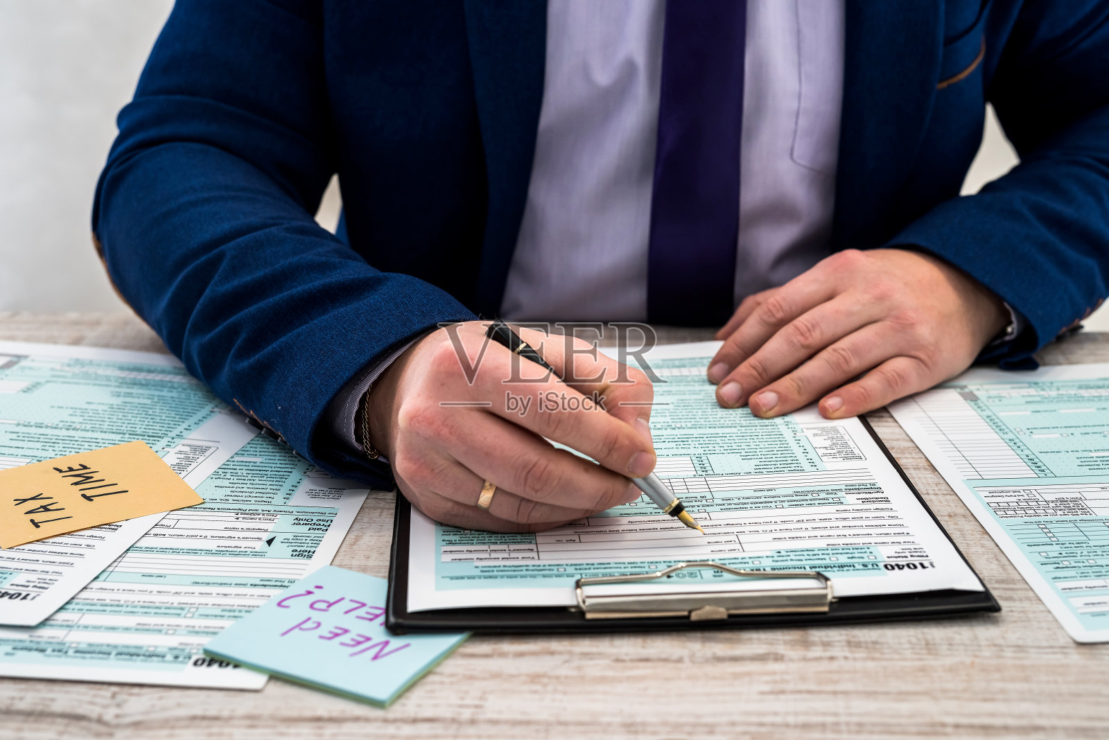 西装男填写美国个人1040税表。税收的时间照片摄影图片