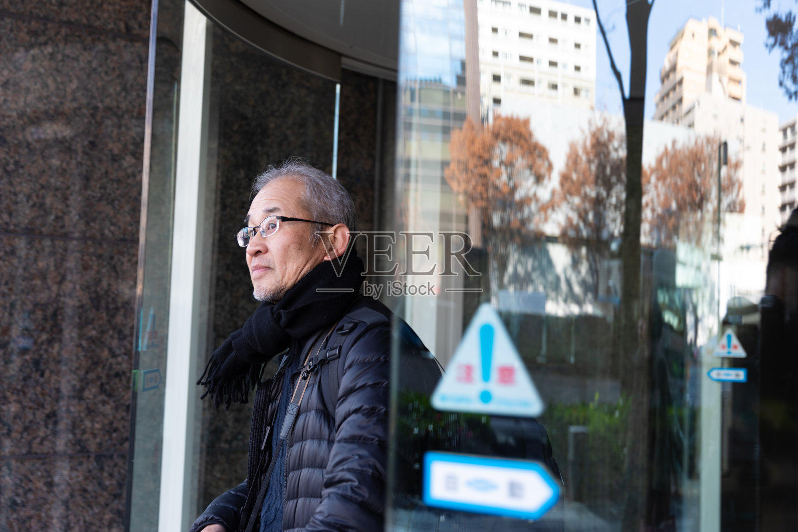 一位长者从大楼里走出来照片摄影图片