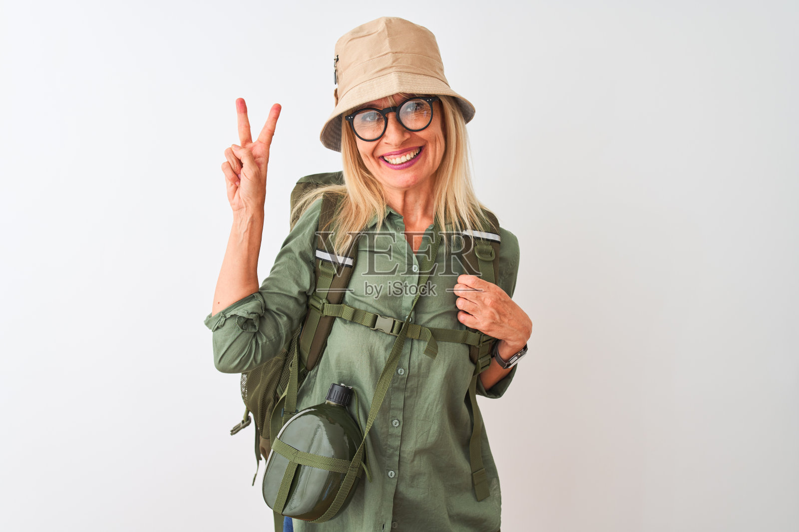 面带自信和快乐笑容,竖起两根手指的中年徒步女性照片摄影图片