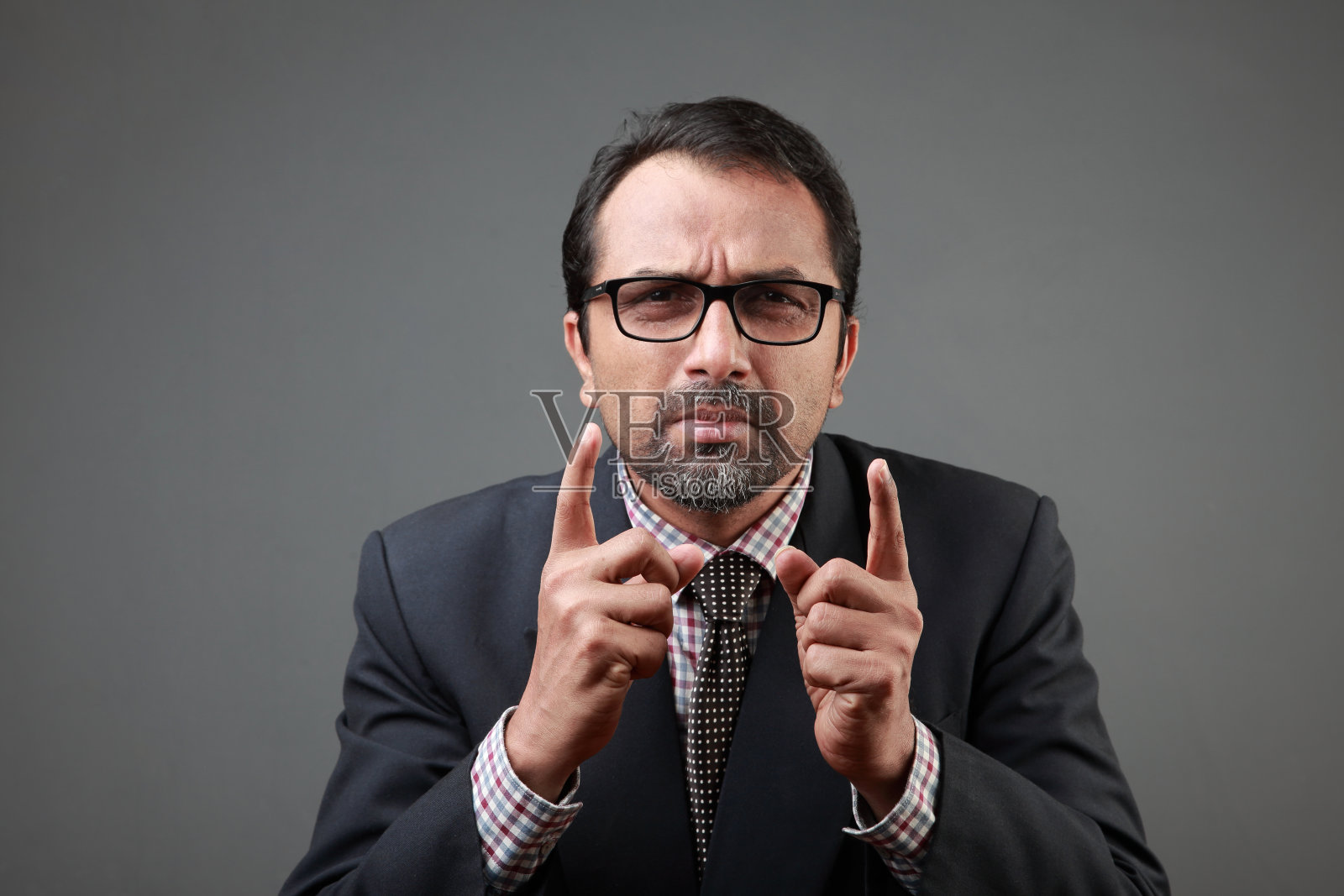 一位中年专业人士伸出食指表示怀疑照片摄影图片