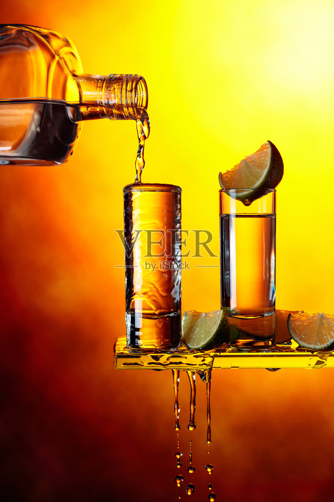 龙舌兰酒,柠檬片,黄色背景。照片摄影图片