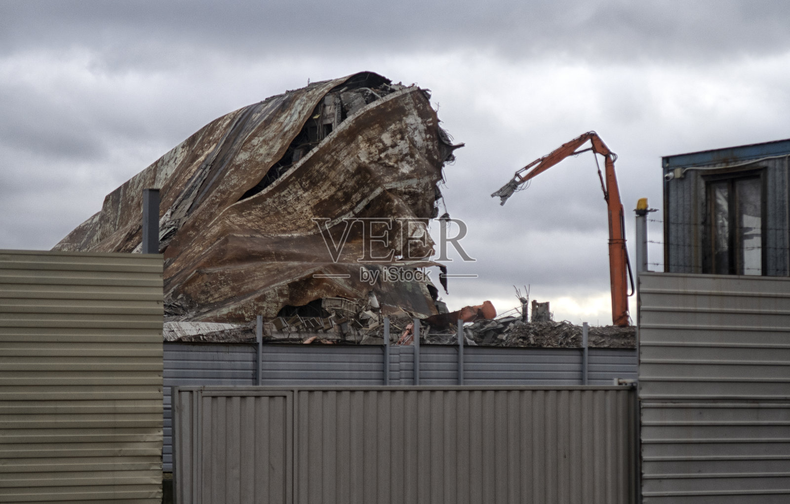 用挖掘机-驱逐舰拆除建筑物用于高空作业。照片摄影图片