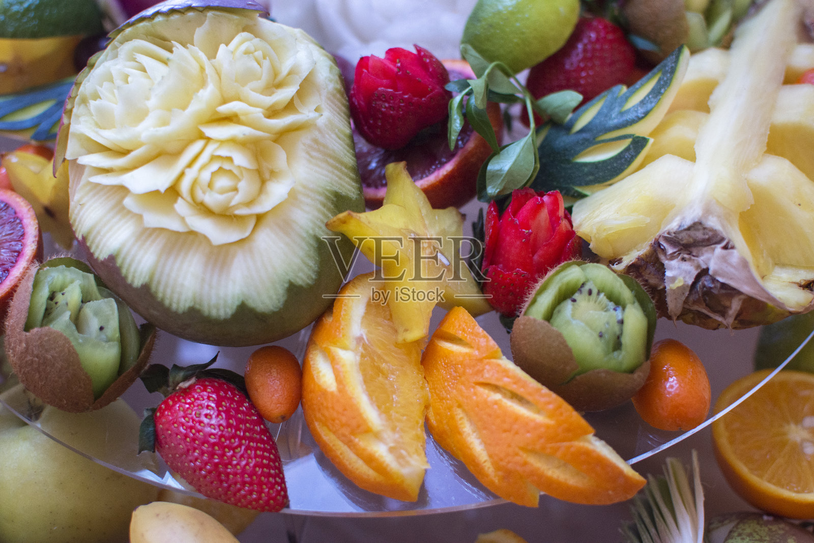 切得很漂亮的水果摆在节日餐桌上。在节假日和活动期间为客人提供膳食。卡文水果。照片摄影图片