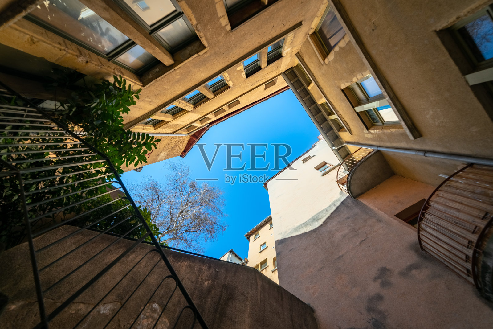 Traboule里昂。原始和对称的建筑物和蓝天的镜头照片摄影图片