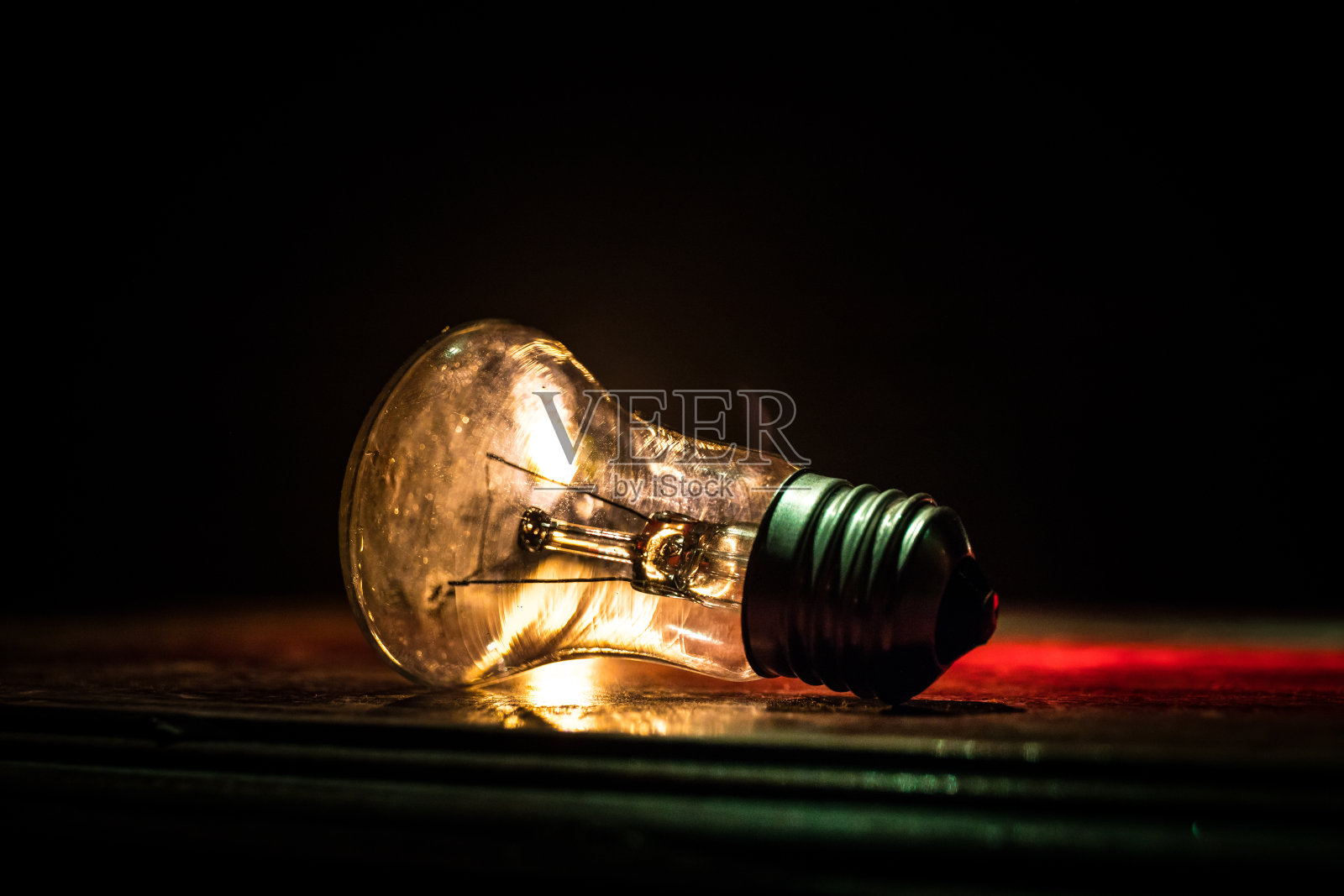 抽象的深色背景与发光的灯泡创意艺术品装饰。照片摄影图片