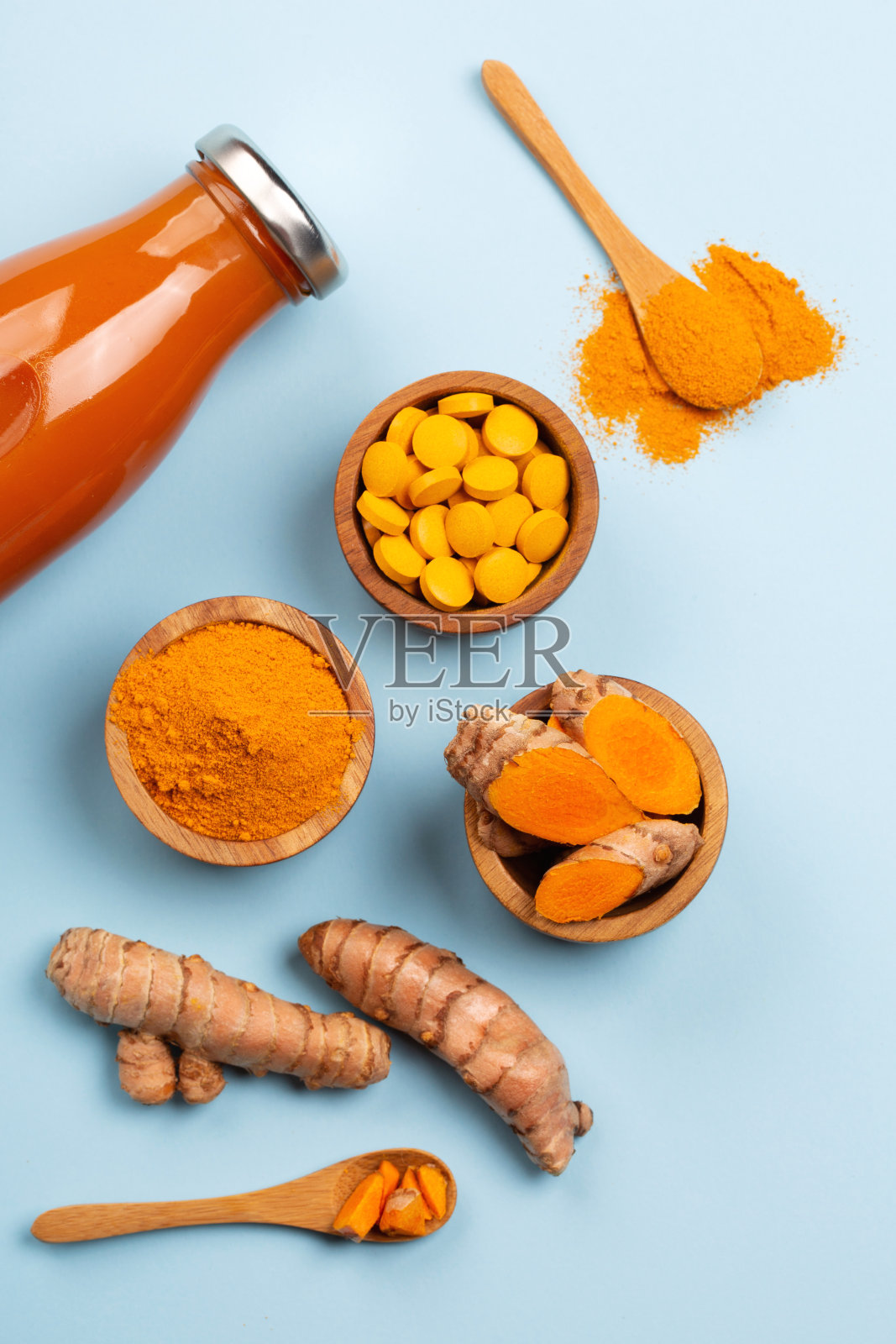 不同条件下的姜黄:鲜、干根、丸剂、粉剂和切块植物。照片摄影图片