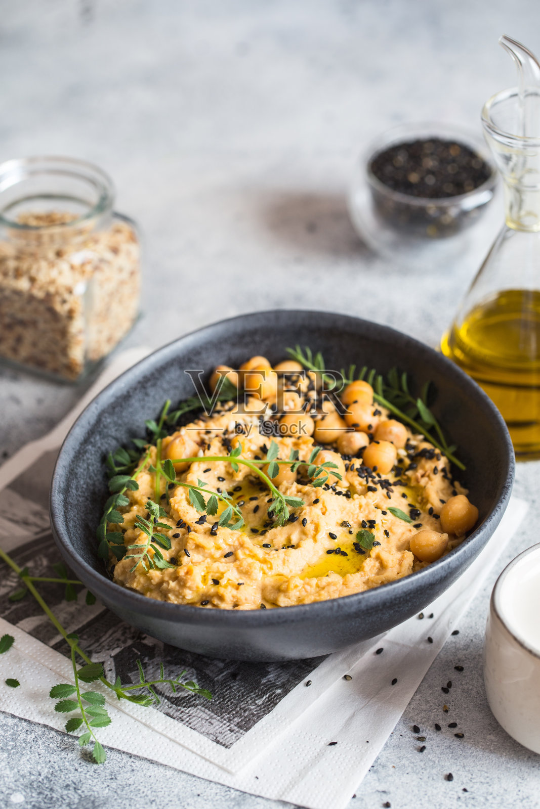 黑碗鹰嘴豆泥,点缀芝麻和鹰嘴豆。素食食谱,植物菜肴。绿色生活的概念。有机食品。素食菜。照片摄影图片