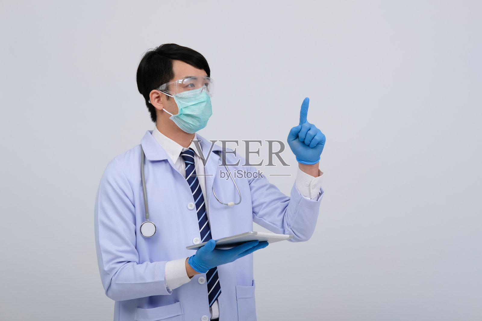 戴口罩的医生手持平板电脑和听诊器照片摄影图片