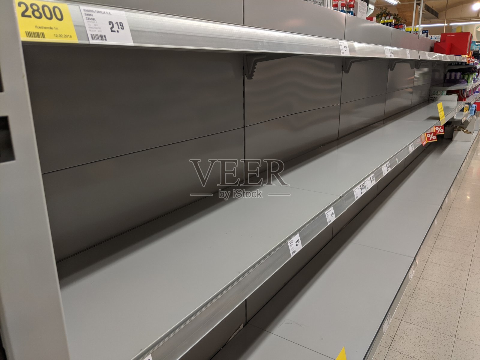 由于新冠病毒的爆发,超市的厕纸货架被抢购一空,意思是:“由于不可预测的抢购,没有库存。”照片摄影图片