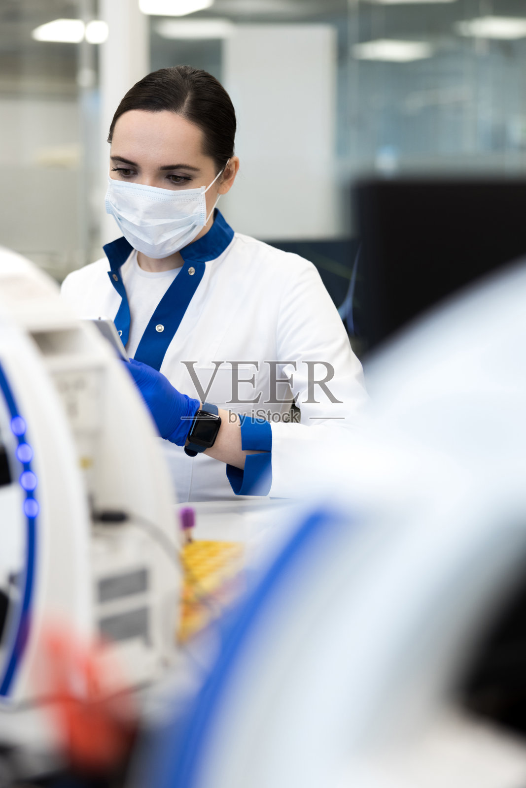 戴着医用口罩在实验室工作的女科学家照片摄影图片