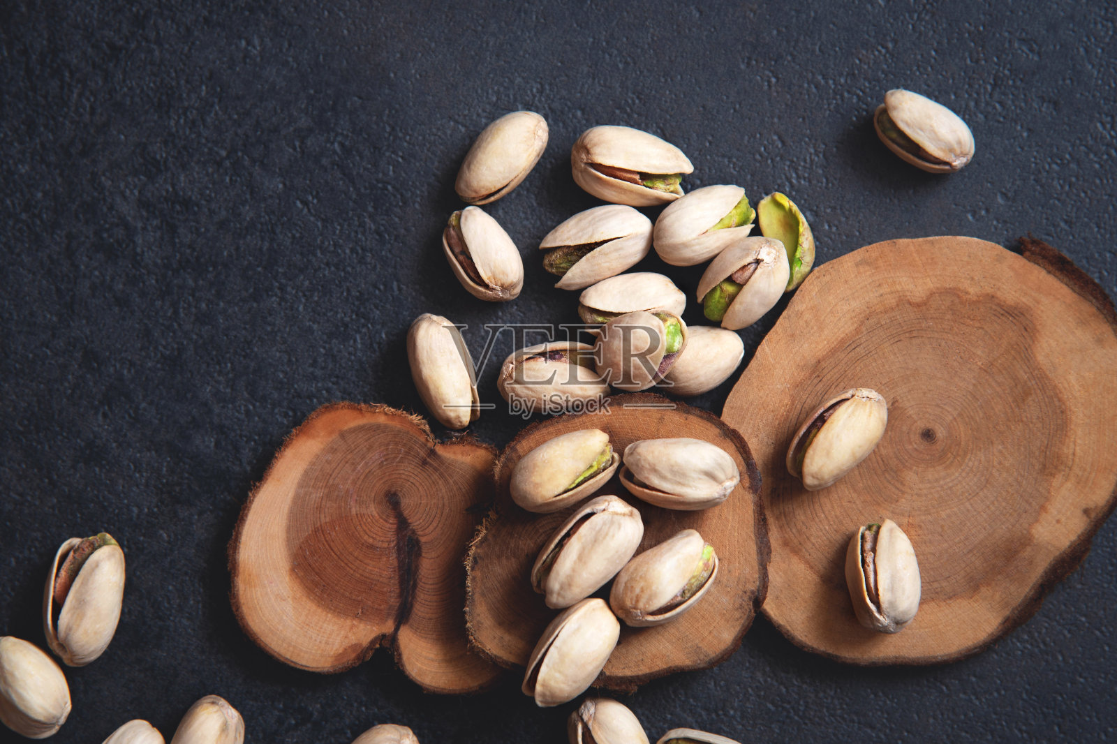 深色背景上的烤开心果。健康的零食照片摄影图片