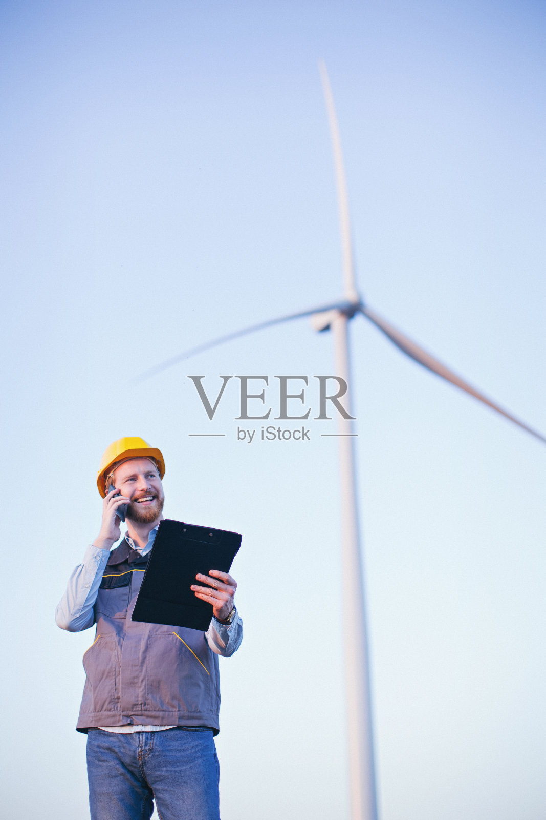 风车前的年轻电气工程师照片摄影图片