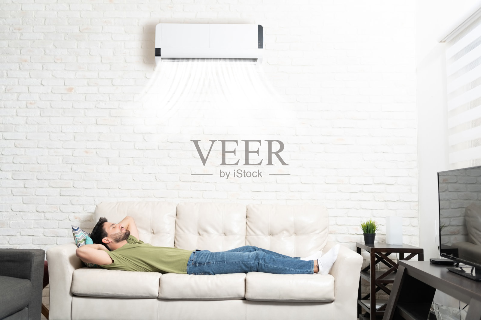 睡在家里空调下面沙发上的拉丁人照片摄影图片