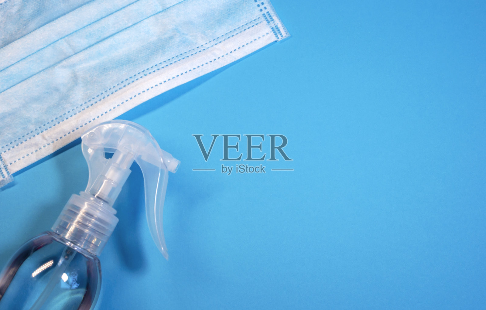 医用防护口罩和消毒剂,蓝色背景,拷贝空间,俯视图。冠状病毒爆发国防照片摄影图片